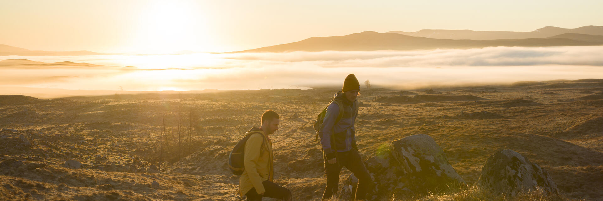 Deux hommes faisant une randonnée dans les hautes terres au coucher du soleil. Rayons de soleil