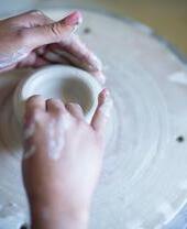 Close up female artist at pottery wheel