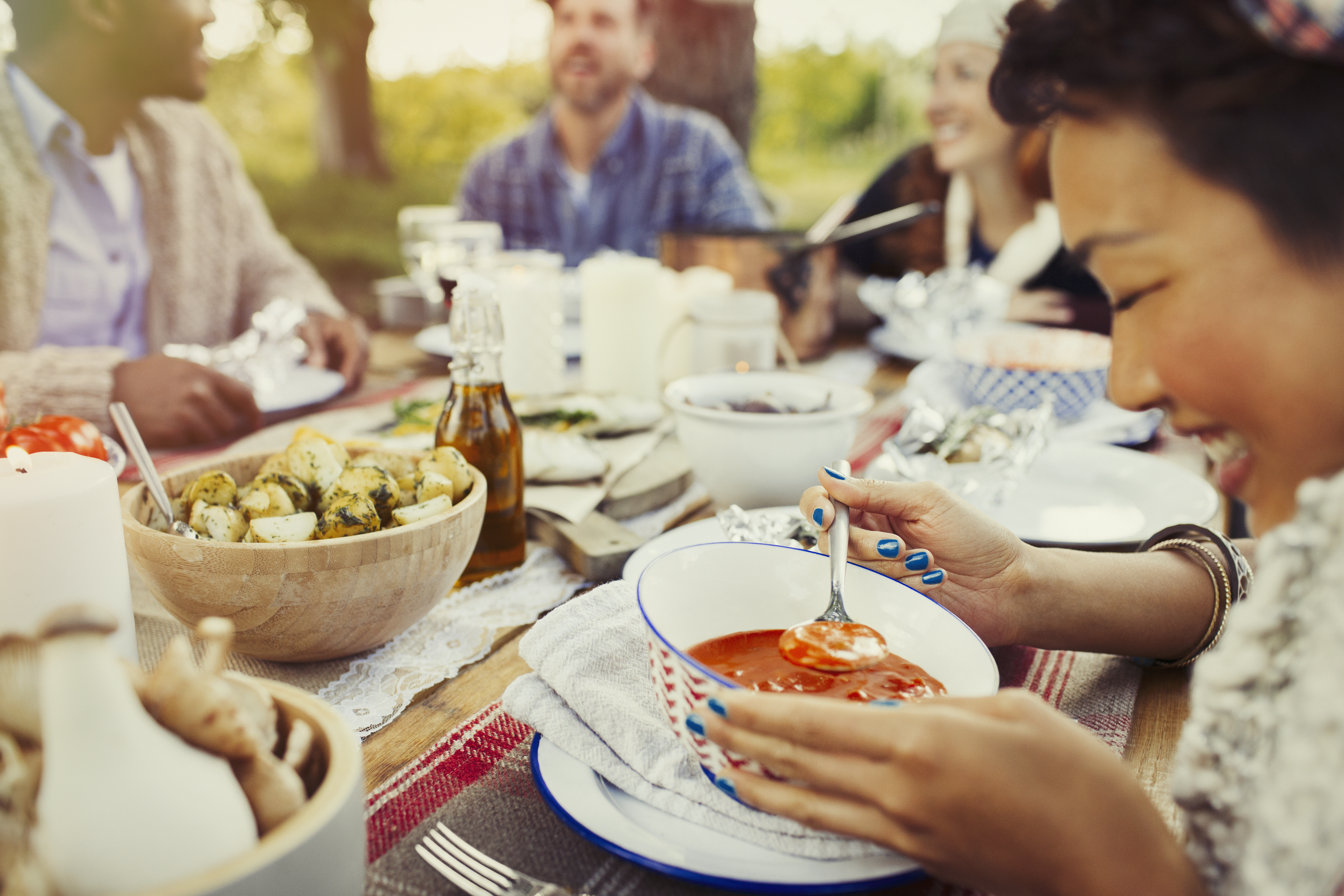 People eating a meal outdoors at a large table