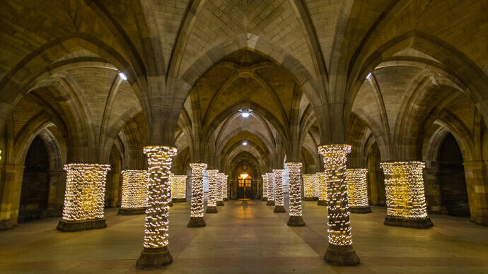 Fairy lights wrapped around pillars in a cloister