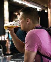 Uomo che beve una pinta alla Tennent's Wellpark Brewery