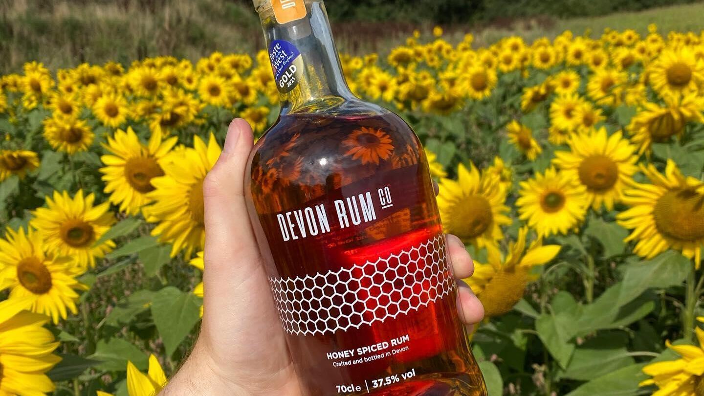 Estate - Una persona con una bottiglia di rum alla Quince Honey Farm