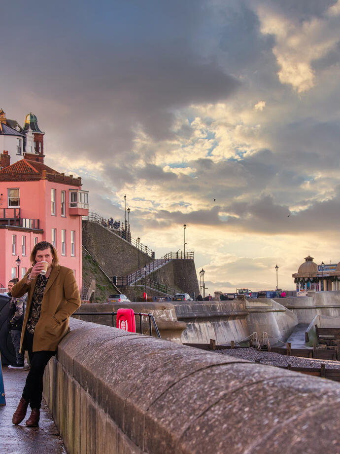 Groups of people stood on the promenade looking out on Cromer Beach
