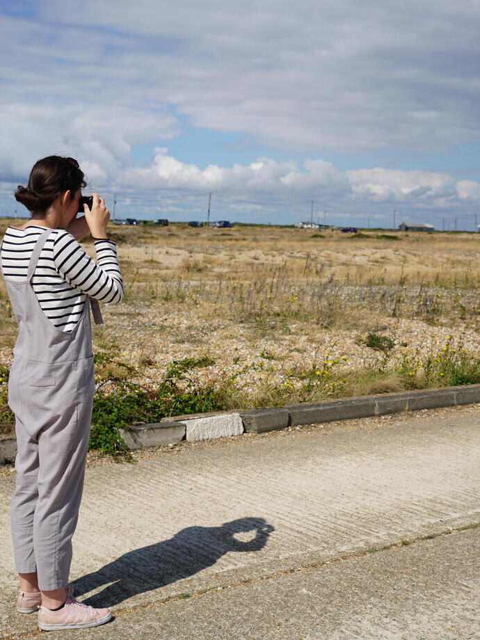 A female photographer in the Dungeness Landscape.