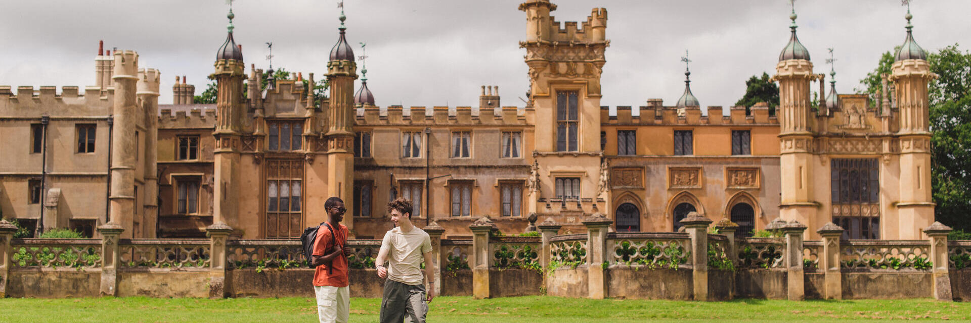 Two young men walk in the grounds of a heritage house