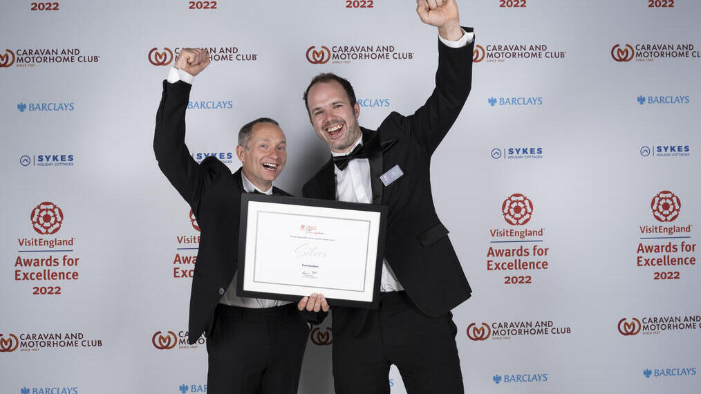 Photo of Silver Winners for Ethical, Responsible and Sustainable Tourism Award - Pure Outdoor - in front of the branded photo backdrop