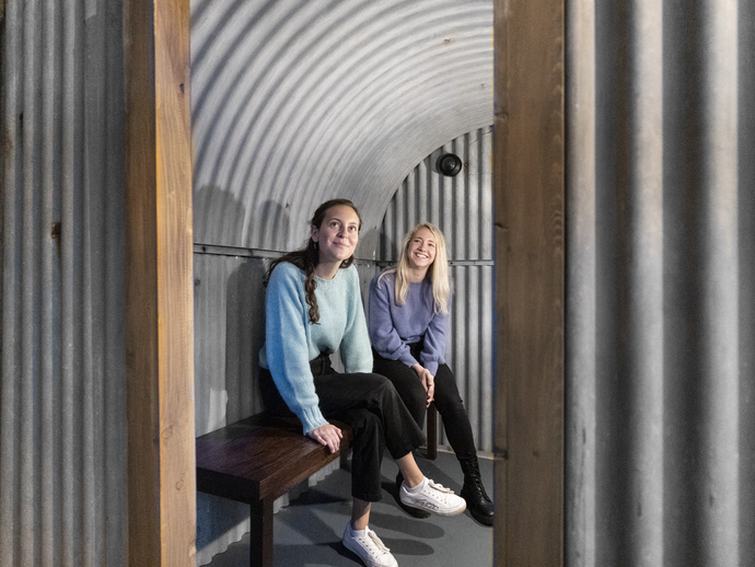 Two women sitting in a replica shelter in the Imperial War Museums, London