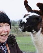 A woman posing with an alpaca at Middle England Farm