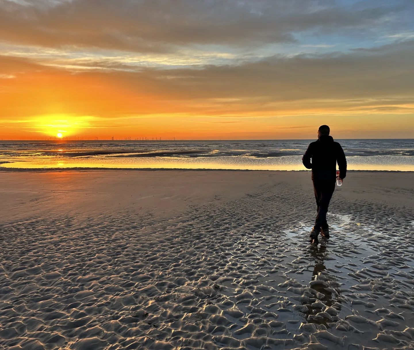 Autumn-island escape. Man walking on a beach