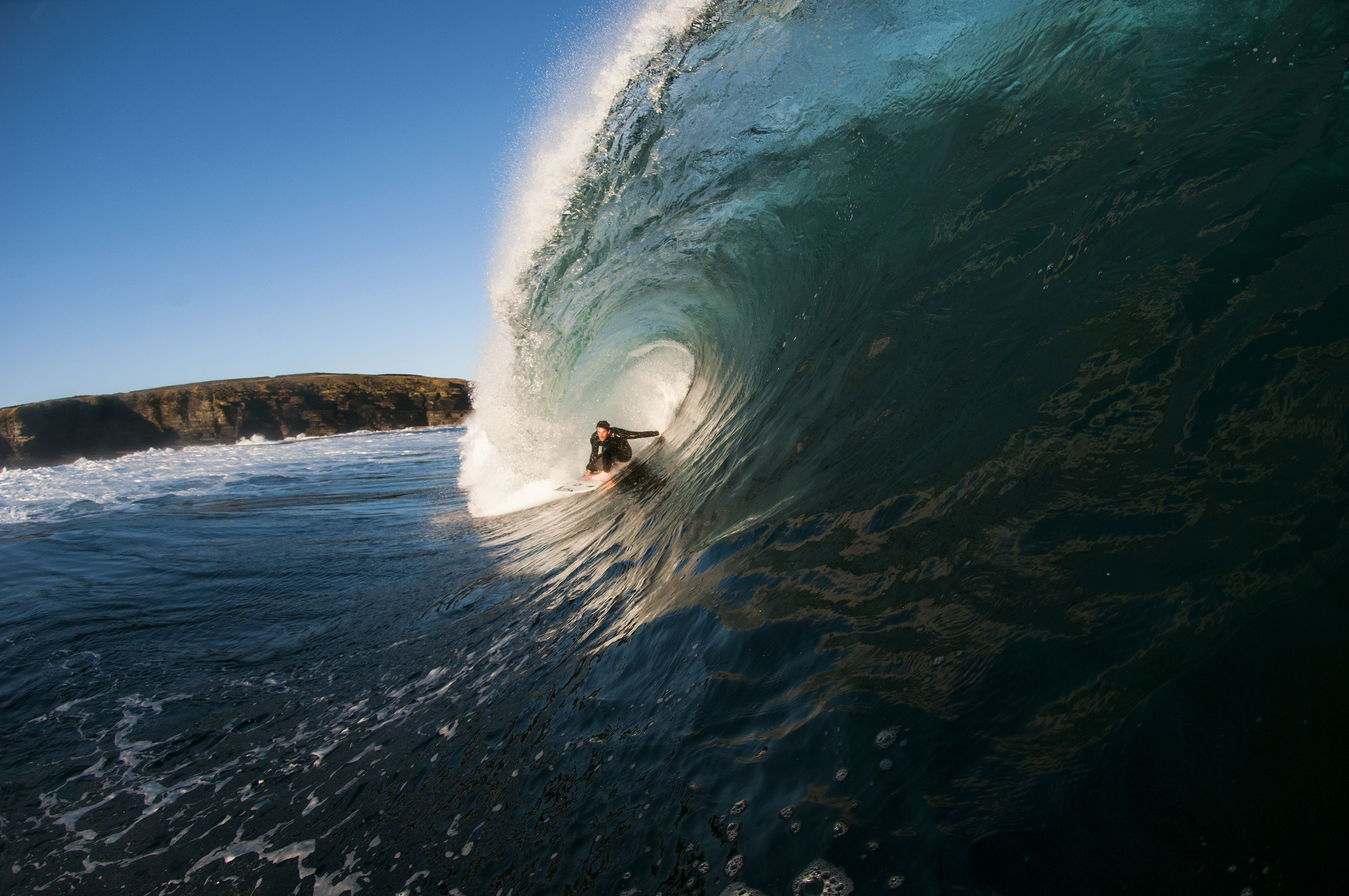 Homme surfant sur une vague géante dans la mer