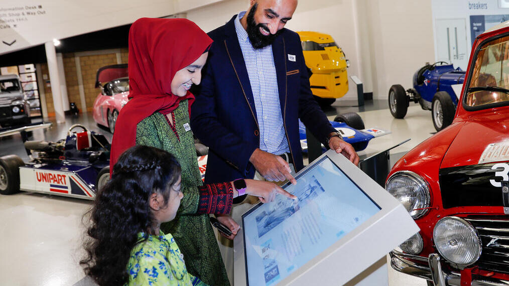A family looking at an interactive exhibit at the British Motor Museum