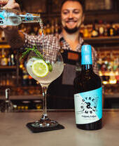 Un barista che versa un cocktail con gin costiero al Gyre & Gimble di Norwich