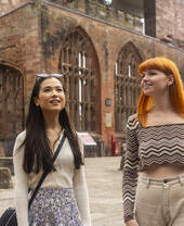 Dos mujeres exploran las ruinas dentro de los terrenos de una catedral