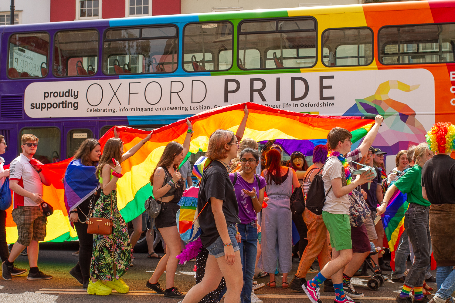 Menschenmassen vor einem regenbogenfarbenen Bus im Rahmen der Oxford Pride