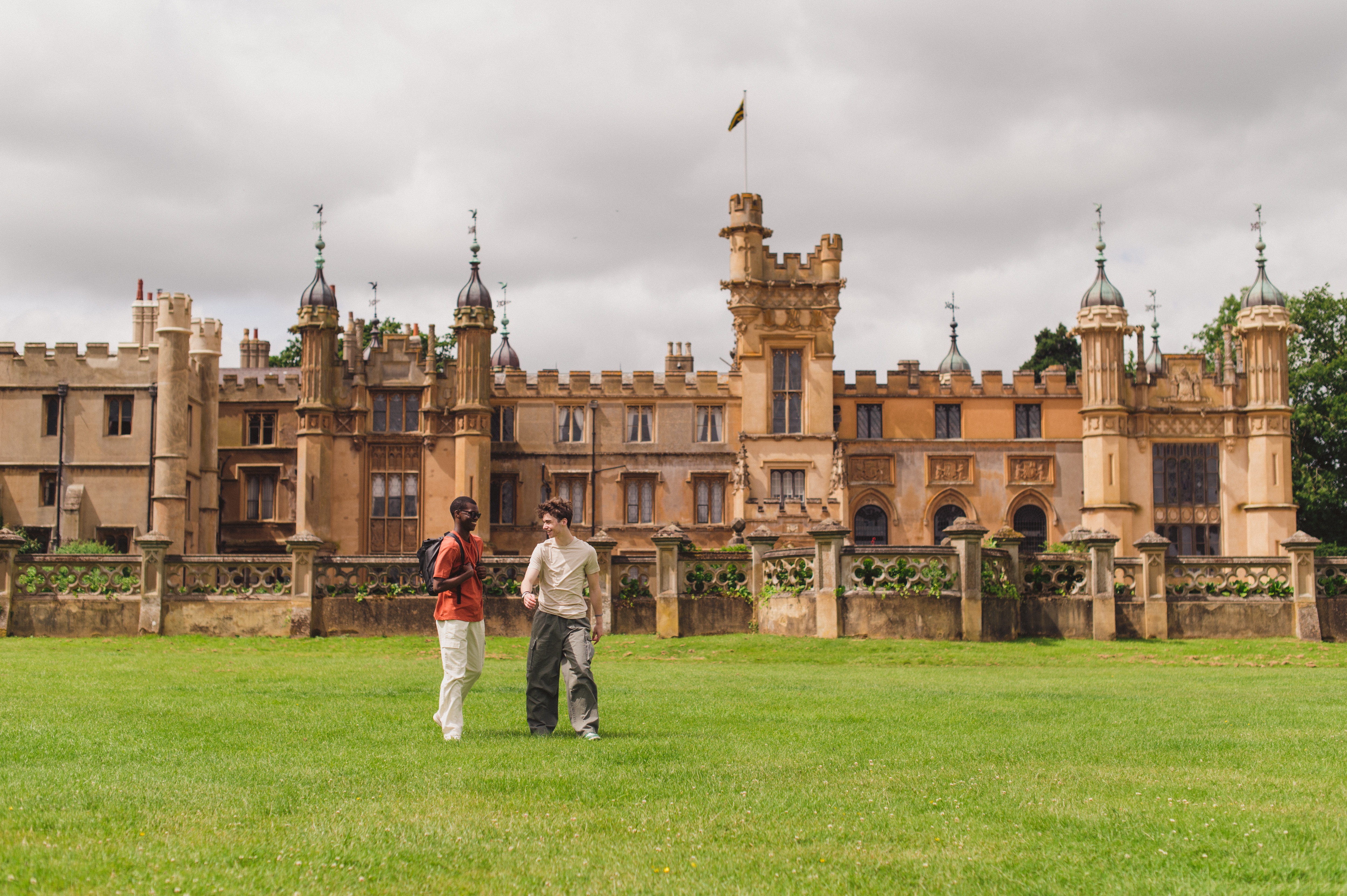 Two young men walk in the grounds of a heritage house