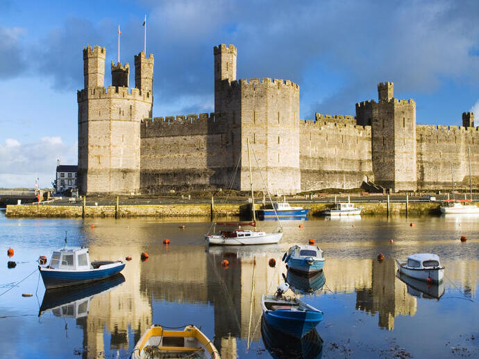 Rowing boats on the water in front of a large castle
