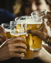 Inquadratura di mani che fanno tintinnare bicchieri di birra