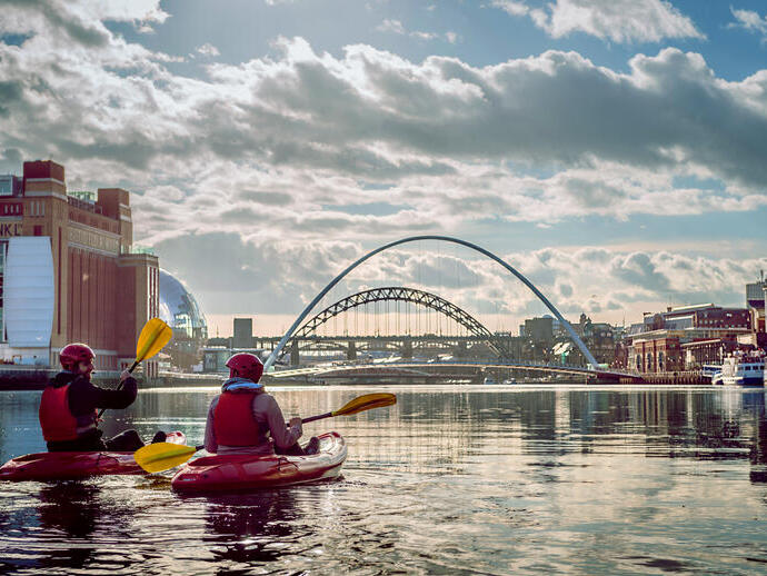 Couple kayaking in a city river.