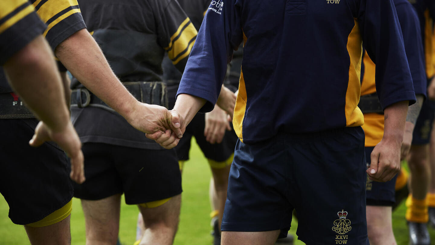 Competitors shake hands after the tug of war