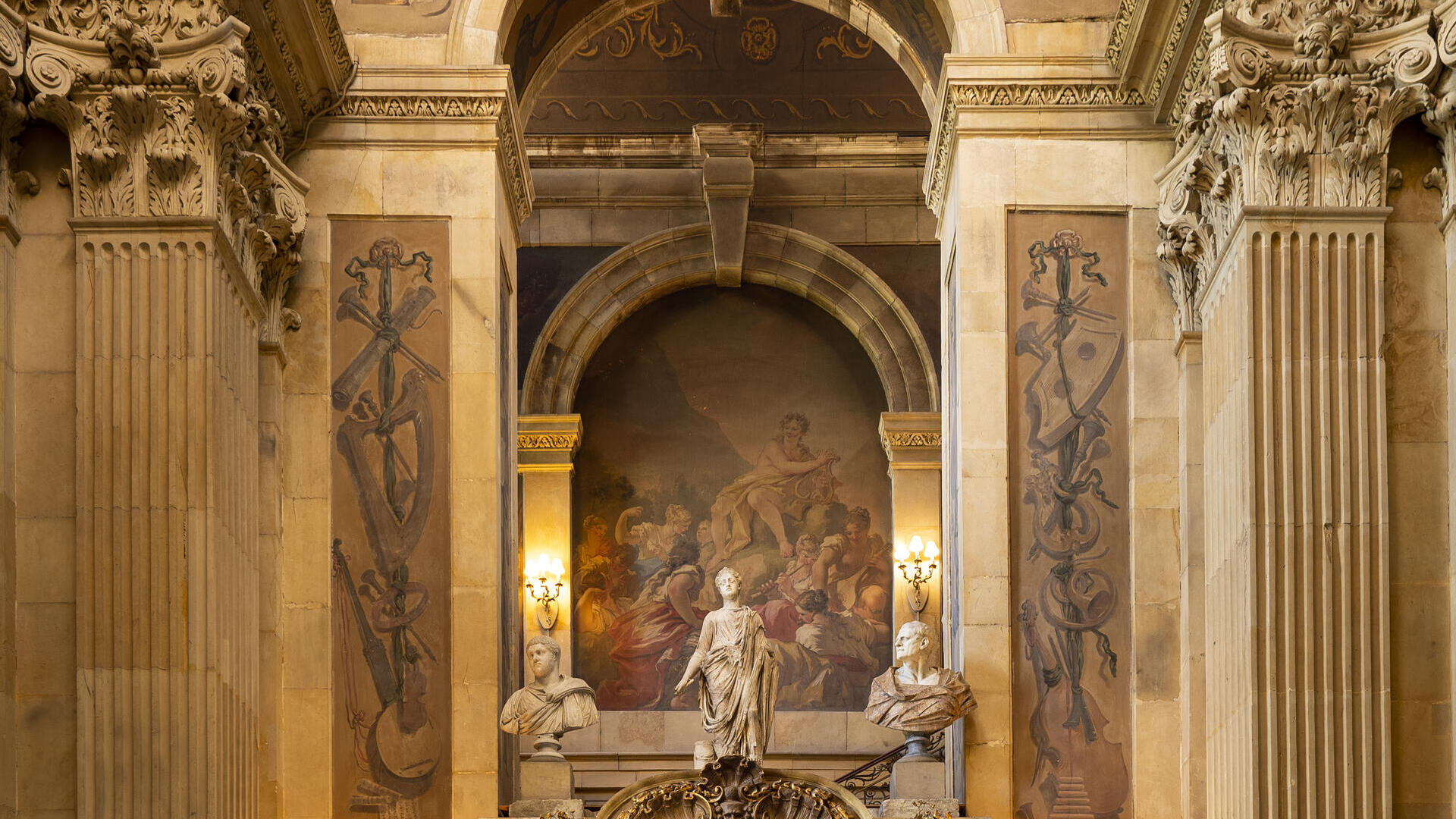 Interior shot of ornate fireplace and arch with painted ceiling and frescoes