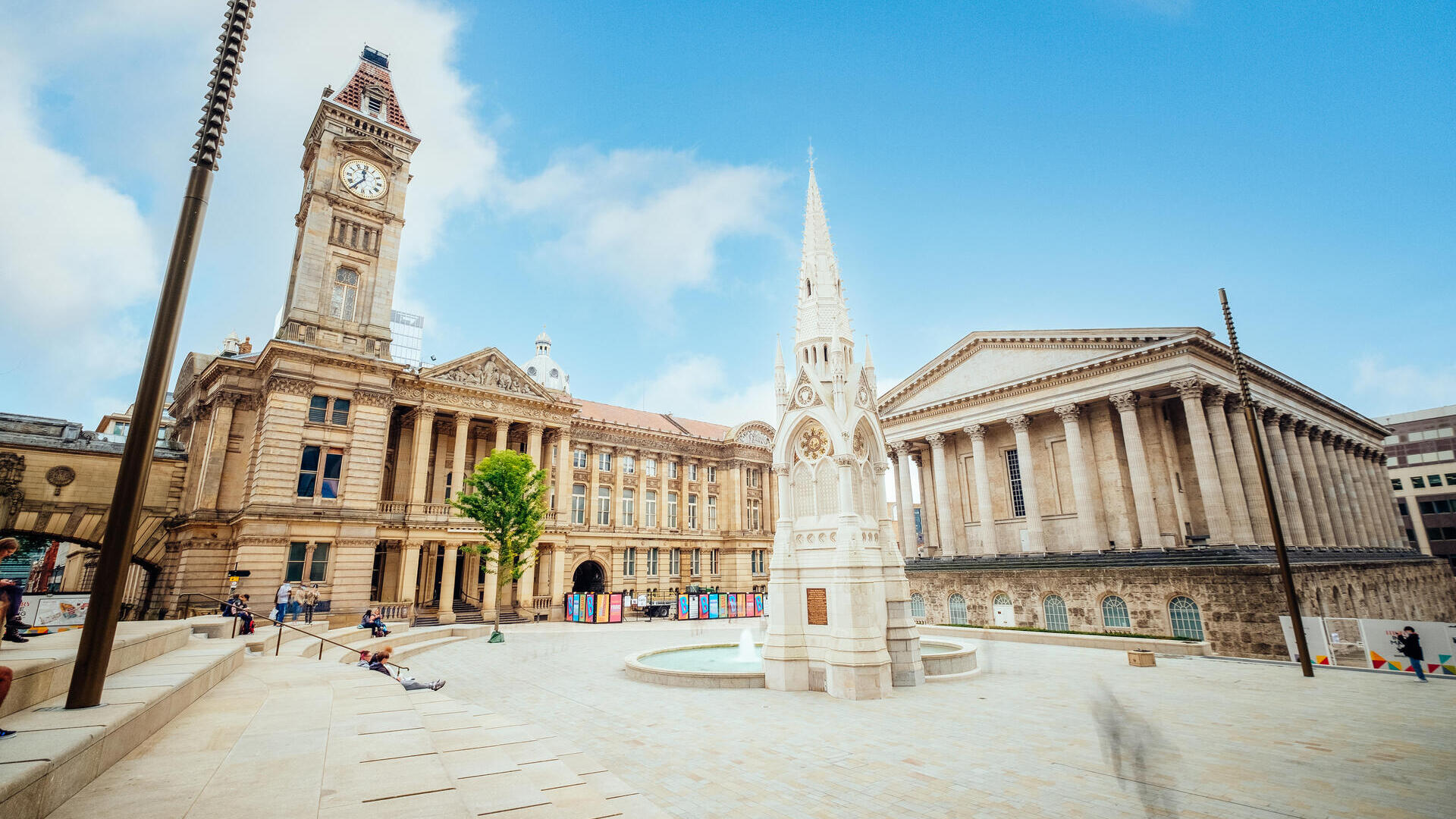 Historical building, with a clock tower, beside a fountain