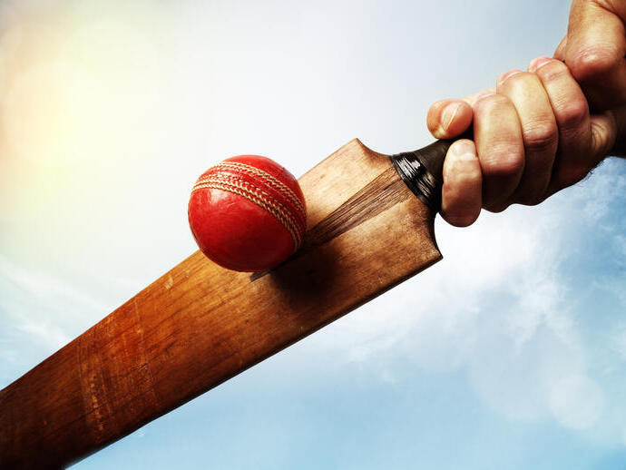 Una pelota y un bate de críquet antiguos.