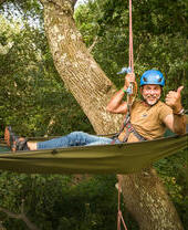 Man hanging from trees in hammock