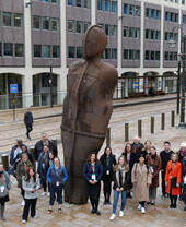 A tour group posing alongside a statue in Birmingham as part of a Positively Birmingham walking tour