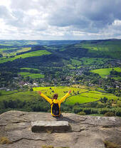 Una donna con le braccia alzate che si gode il panorama dall'alto