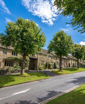 A tree lined street in Burford village