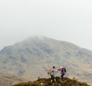 Couple hiking in the mountains on a cloudy day