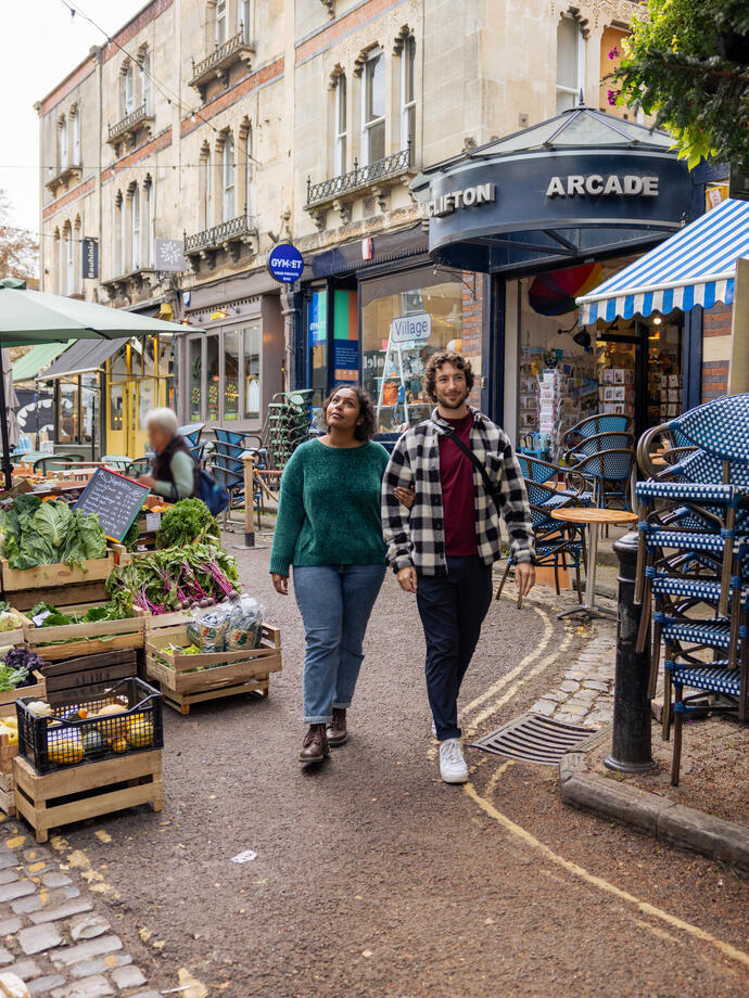 Friends walking through a market in a city street.