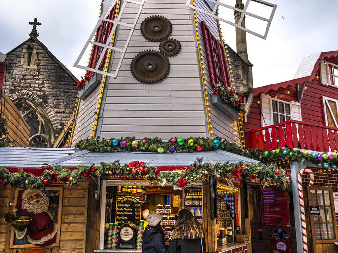 Twee vrouwen die voor een kraam op een kerstmarkt staan