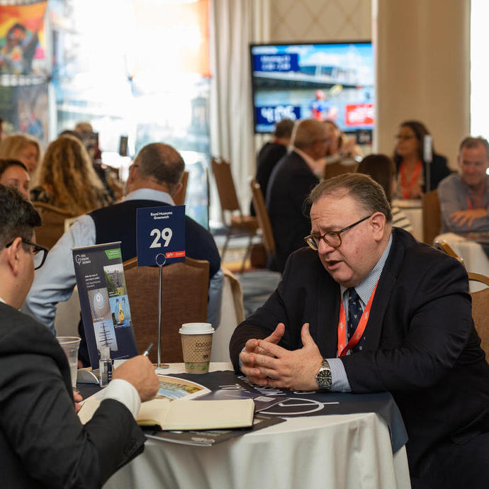 Attendees of an event sit at a table and talk