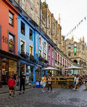 People walking in a street in a city lined with shops