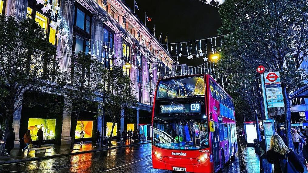 Oxford Street de noche con un autobús rojo londinense