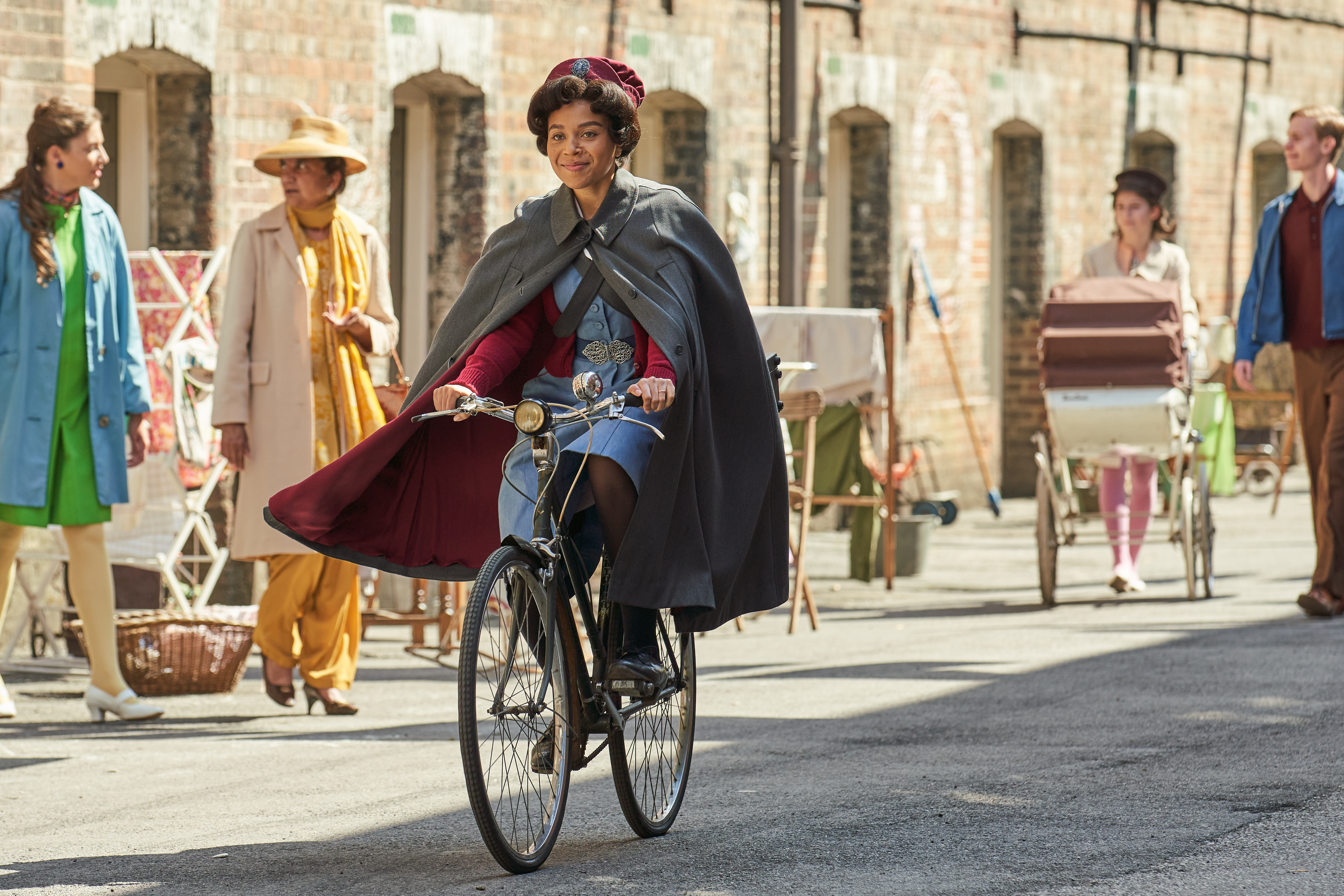 Woman dressed up in 1950's nurse costume riding a bike