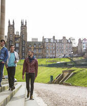 Three men walking on steps beside large columns