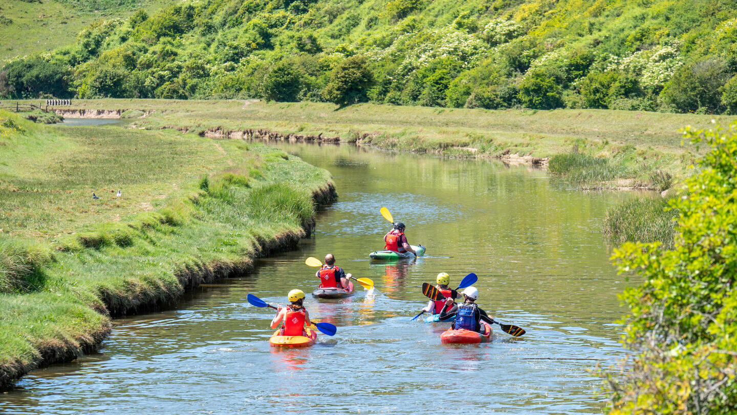 Un gruppo di persone in kayak lungo il fiume Cuckmere nell'East Sussex