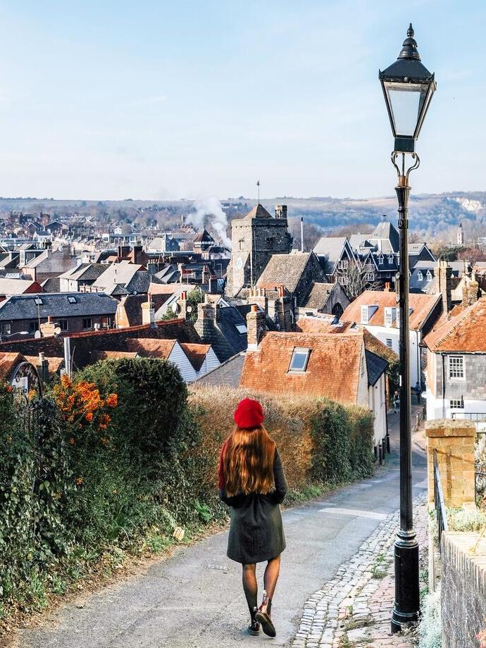 Girl looking down a countryside road to a village below