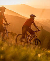 Two men on mountain bikes cycling at Devil's Dyke. Sunrise