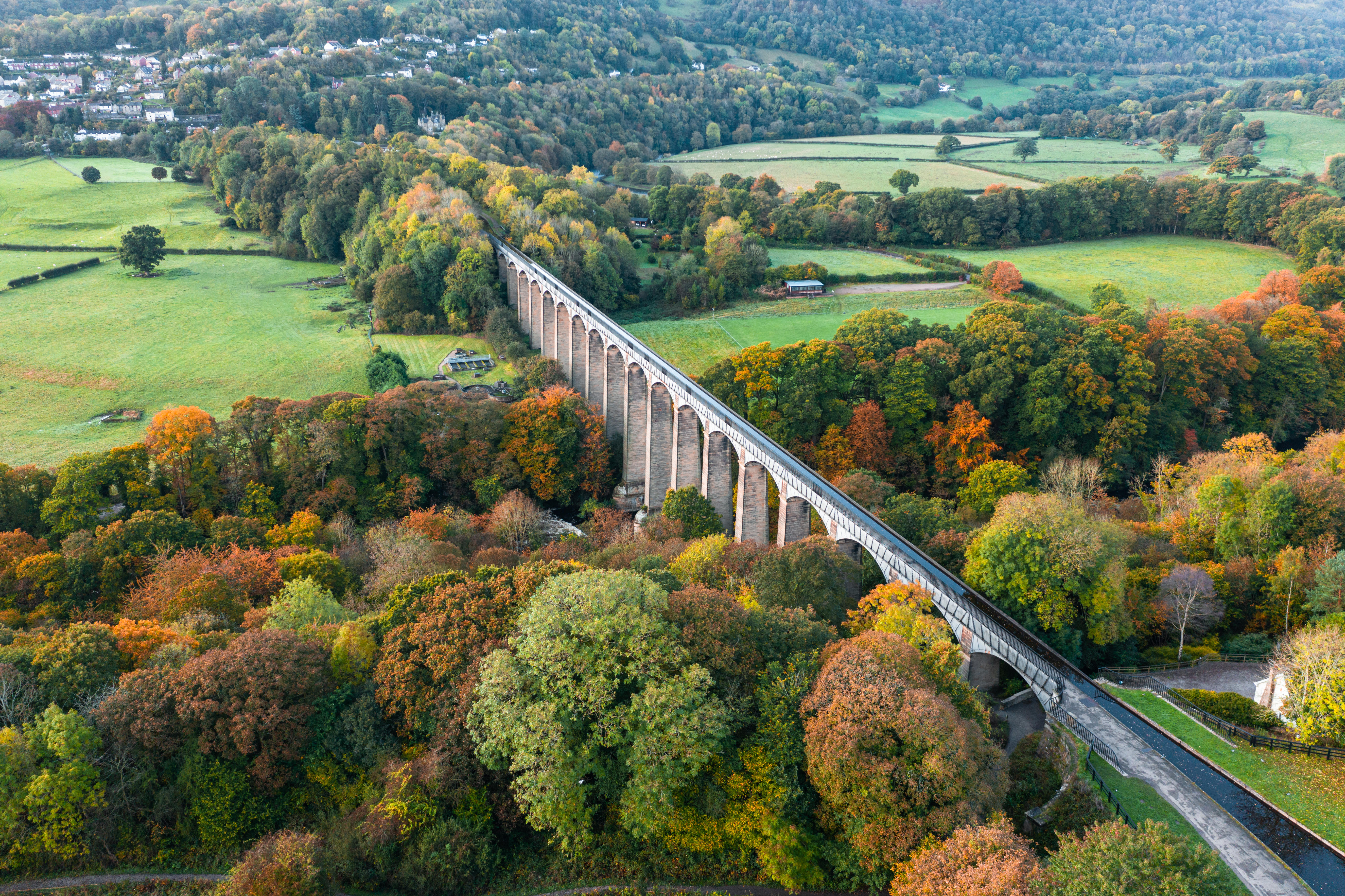 Aerial view of a long viaduct spanning river in an autumnal setting