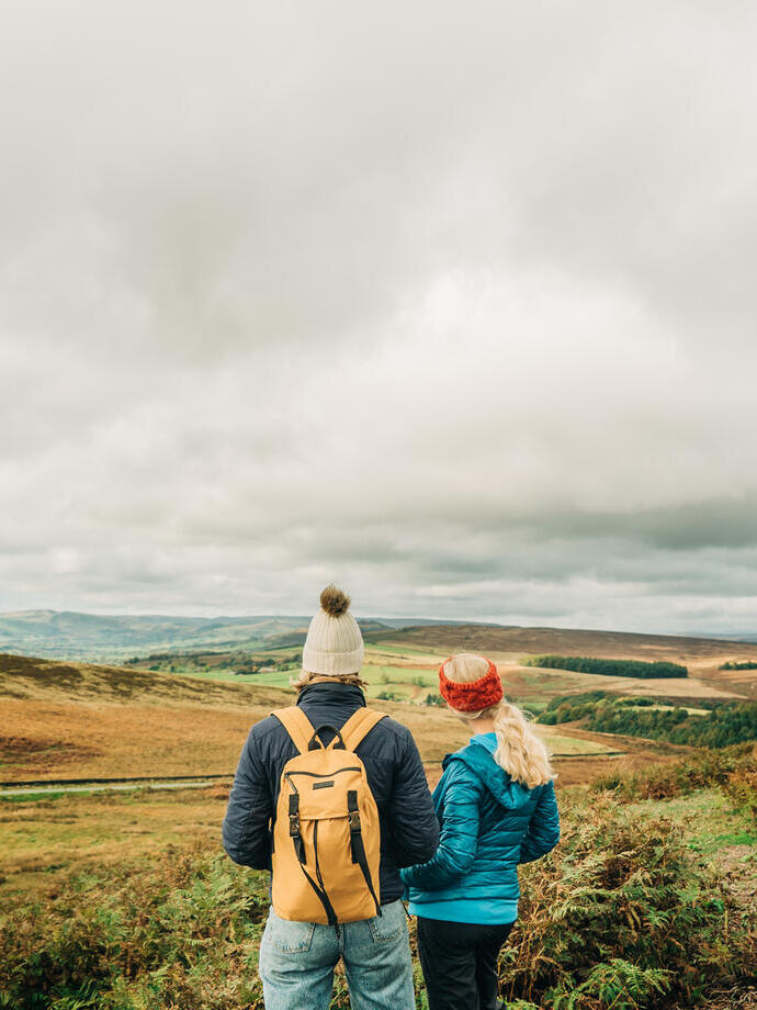 Two girls walking with panoramic views of greenery