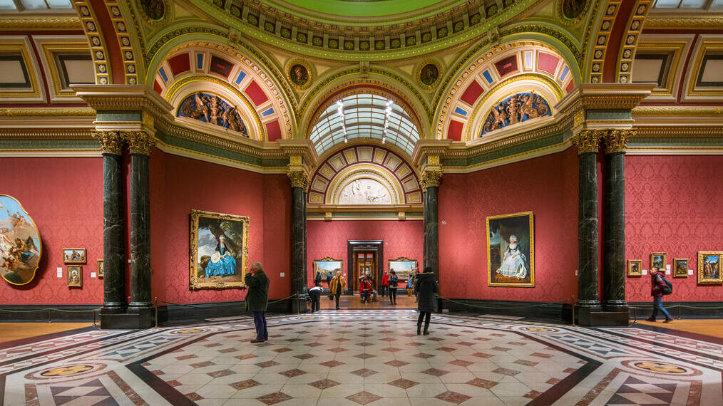 People viewing paintings inside the National Gallery in London