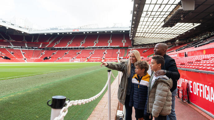 Une famille regarde un stade de football vide depuis les gradins.