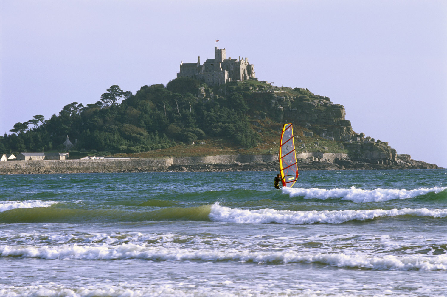 Eine Person beim Windsurfen vor der Küste des Schlosses auf St. Michael's Mount, Cornwall