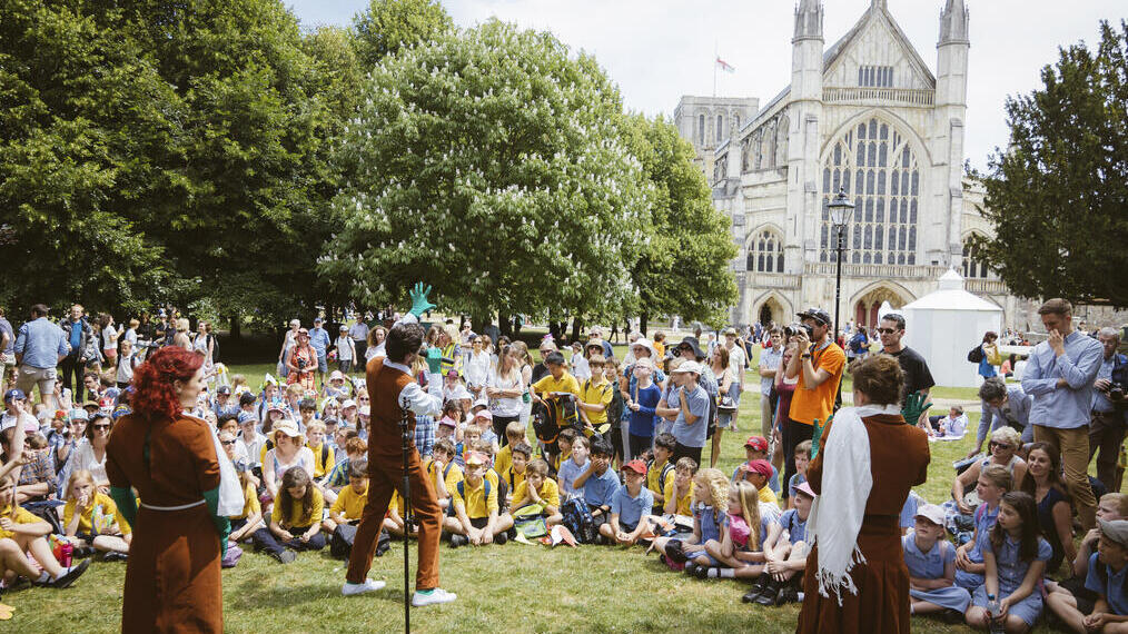 Performance in front of an audience on a lawn near cathedral