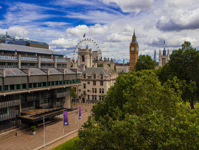 Wide shot of cityscape with clock tower and Ferris wheel