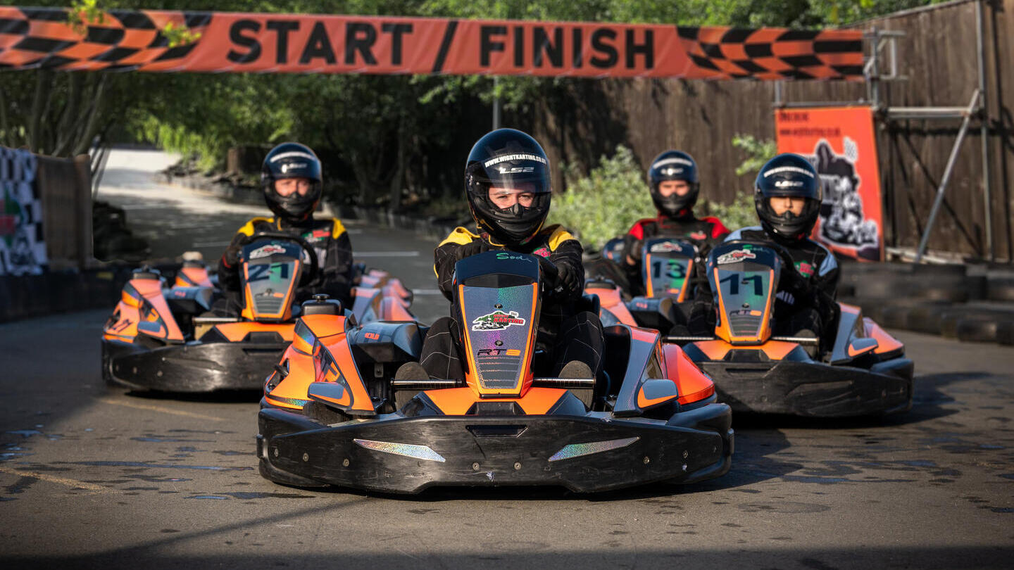 Eine Gruppe von Menschen, die mit Go-Karts Rennen fahren