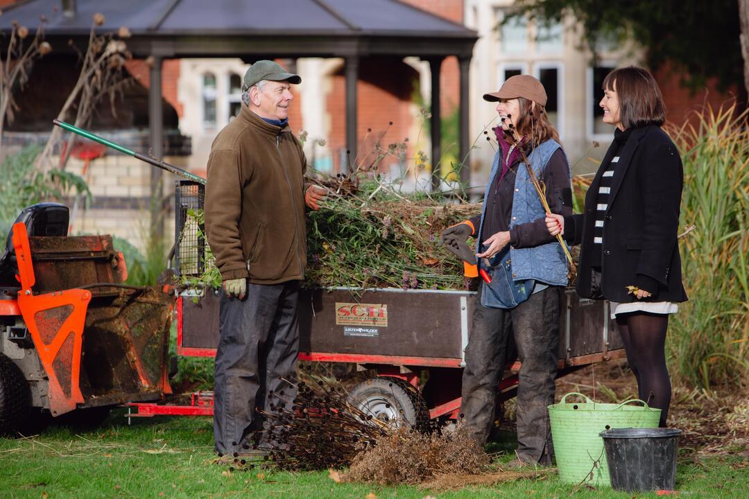 Three people gardening in a garden